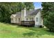 Back exterior view of home featuring a deck and grassy area, with mature trees and landscaping at 136 Walkers Pond Dr, Villa Rica, GA 30180