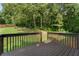 View from the backyard deck overlooking a grassy lawn with wooded perimeter. Great space for outdoor activities and relaxation at 136 Walkers Pond Dr, Villa Rica, GA 30180