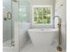 Modern bathroom with a glass-enclosed shower, a soaking tub and a window view at 136 Walkers Pond Dr, Villa Rica, GA 30180