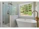 Luxury bathroom with a glass-enclosed shower, a soaking tub and a window view at 136 Walkers Pond Dr, Villa Rica, GA 30180