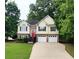 Inviting two-story home featuring a bright red front door, two-car garage, and well-maintained lawn at 136 Walkers Pond Dr, Villa Rica, GA 30180
