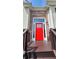 Striking bright red front door with decorative window panes, framed by a brick facade at 136 Walkers Pond Dr, Villa Rica, GA 30180