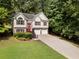 Charming two-story home with a brick facade, a vibrant red front door, and a well-manicured lawn at 136 Walkers Pond Dr, Villa Rica, GA 30180