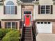 Inviting home with brick accents, a striking red front door, and an attached two-car garage at 136 Walkers Pond Dr, Villa Rica, GA 30180