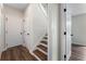 Hallway with hardwood floors, a staircase with wooden steps, and white doors at 136 Walkers Pond Dr, Villa Rica, GA 30180