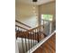 Stylish staircase with wooden treads and black iron balusters, leading to a bright entryway at 136 Walkers Pond Dr, Villa Rica, GA 30180