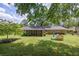 Large backyard features a home with a screened in patio, mature trees, and a playhouse at 1732 Samaria Trl, Tucker, GA 30084