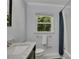 Well-lit bathroom showcases a single sink vanity, tiled shower and window with a lush outdoor view at 1732 Samaria Trl, Tucker, GA 30084