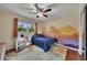 This bedroom boasts a ceiling fan and natural light, with a unique mural on the wall at 1732 Samaria Trl, Tucker, GA 30084