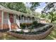 Attractive home with a covered porch, brick steps, and professionally landscaped garden beds at 1732 Samaria Trl, Tucker, GA 30084