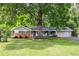 Charming one-story home featuring a brick facade, well-manicured lawn, and a beautiful mature tree at 1732 Samaria Trl, Tucker, GA 30084