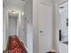 Hallway featuring hardwood floors, gray walls, a vibrant rug and an open door to the bathroom at 1732 Samaria Trl, Tucker, GA 30084