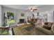 Open-concept living room features a painted brick fireplace, a ceiling fan, and a view of the backyard at 1732 Samaria Trl, Tucker, GA 30084