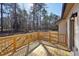 Exterior wooden deck with decorative black outdoor light fixture and forested backyard at 3279 Greenhill Dr, Villa Rica, GA 30180