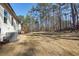View of the home's backyard and side yard featuring a wooden deck and grassy area with trees at 3279 Greenhill Dr, Villa Rica, GA 30180