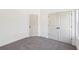 Bright bedroom featuring neutral carpet, white walls, and doors at 3279 Greenhill Dr, Villa Rica, GA 30180