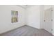 Bright bedroom featuring neutral carpet, white walls, and a window with views of a wooded backyard at 3279 Greenhill Dr, Villa Rica, GA 30180