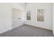 Bright bedroom featuring neutral carpet, white walls, and windows with views of a wooded backyard at 3279 Greenhill Dr, Villa Rica, GA 30180