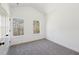 Bright bedroom featuring neutral carpet, white walls, and windows with views of a wooded backyard at 3279 Greenhill Dr, Villa Rica, GA 30180