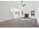Sun-filled living room with plush carpet, stone fireplace, and an adjacent kitchen with bar seating at 3279 Greenhill Dr, Villa Rica, GA 30180