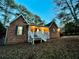 Charming brick home with a welcoming front porch and green shutters at twilight at 342 Mccurry Rd, Stockbridge, GA 30281