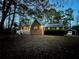 Brick home with white porch and red garage, surrounded by tall trees at dusk at 342 Mccurry Rd, Stockbridge, GA 30281