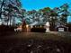 Brick home with white porch and red garage surrounded by lush trees at dusk at 342 Mccurry Rd, Stockbridge, GA 30281