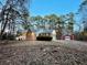 Brick home with white porch and red garage, surrounded by tall trees at 342 Mccurry Rd, Stockbridge, GA 30281