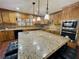 Kitchen with granite counters, wood cabinets, black appliances, and a large island with seating at 342 Mccurry Rd, Stockbridge, GA 30281
