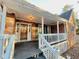 View of a covered front porch with white railings and brick columns, leading to the front door at 342 Mccurry Rd, Stockbridge, GA 30281