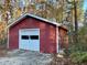 Exterior view of a red wooden shed with a white garage door on a property at 342 Mccurry Rd, Stockbridge, GA 30281
