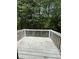 View of backyard deck with white wooden railing surrounded by lush green trees at 5047 Chupp Way Cir, Lithonia, GA 30038
