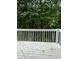 View of backyard deck with white wooden railing surrounded by lush green trees at 5047 Chupp Way Cir, Lithonia, GA 30038