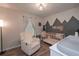 Charming Bedroom with a crib, modern lighting, mountain-themed design on the wall, and a cozy chair at 92 Confidence Ct, Temple, GA 30179