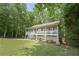 Cozy house with a welcoming front porch and lush green lawn surrounded by mature trees at 92 Confidence Ct, Temple, GA 30179