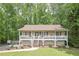 Charming home featuring a large front porch, well-maintained lawn, and mature trees at 92 Confidence Ct, Temple, GA 30179