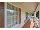 Inviting covered front porch with rocking chairs, bench and decorative wood shutters at 92 Confidence Ct, Temple, GA 30179