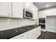 Modern kitchen featuring white cabinets, subway tile backsplash, black countertops and stainless steel appliances at 101 Ruby Lane, Mcdonough, GA 30252