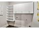 Bright laundry room featuring white cabinets and shelving for optimal storage solutions at 101 Ruby Lane, Mcdonough, GA 30252