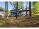 Backyard view of the blue house showing mature trees and screened in porch at 1129 Pinehurst Rd, Grayson, GA 30017