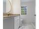 Bathroom features a granite countertop, gold fixtures, and a tiled floor next to a bright window at 1129 Pinehurst Rd, Grayson, GA 30017