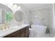 Bathroom featuring modern fixtures, double sink vanity, soaking tub, and marble-look tile at 1129 Pinehurst Rd, Grayson, GA 30017