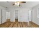 Bright bedroom featuring wood-look flooring, white walls, ceiling fan and doors to closet and bathroom at 1129 Pinehurst Rd, Grayson, GA 30017