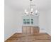 An open, bright dining room featuring hardwood floors, chandelier, and a bay window at 1129 Pinehurst Rd, Grayson, GA 30017