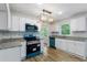 Beautiful kitchen features white cabinets, granite countertops, stainless steel appliances, and hardwood floors at 1129 Pinehurst Rd, Grayson, GA 30017