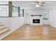 Cozy living room features a brick fireplace, hardwood floors, and a view of the kitchen at 1129 Pinehurst Rd, Grayson, GA 30017