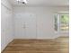 Open living room with hardwood floors, closet, and a large bay window with outdoor views at 1129 Pinehurst Rd, Grayson, GA 30017