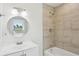 Bathroom featuring a vanity with a round mirror and a shower-tub combination with tiled walls at 130 South Se Ave, Marietta, GA 30060