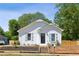Charming white home featuring blue shutters, a black front door, and a newly landscaped yard at 130 South Se Ave, Marietta, GA 30060