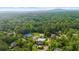 Aerial view of neighborhood, community center, pool, and sports courts amid lush trees at 1358 Peppergrass Nw Trl, Acworth, GA 30101